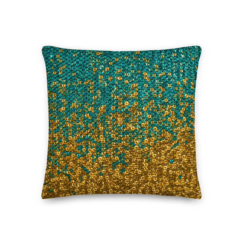 Decorative pillow with gold and teal pattern on a white background