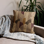 Decorative pillow with abstract pattern on a couch next to a plant