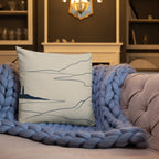 Decorative pillow with abstract design on a couch with blue throw blanket