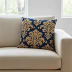 Decorative pillow with gold floral pattern on a blue background on a beige sofa.