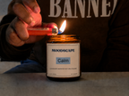 Moodscape Calm candle in a amber jar lit by the owner wearing BANNED hoodie