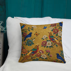 Decorative pillow with birds and flowers on a white surface against a teal curtain background