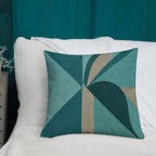 Geometric patterned pillow on a white couch with teal background