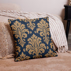 Decorative pillow with gold floral pattern on a blue background, placed on a beige couch.