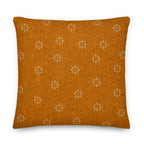Orange pillow with white floral patterns on a white background
