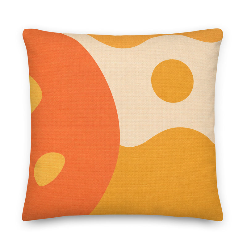 Decorative pillow with orange and yellow abstract design on a beige background