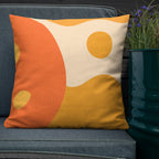 Decorative pillow with orange and yellow abstract design on a blue chair