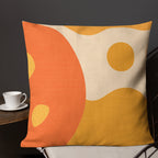 Decorative pillow with orange and yellow abstract design on a dark background