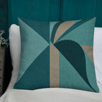 Geometric patterned pillow on a white surface with teal background