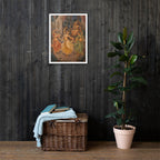 Framed artwork on a dark wooden wall with a wicker basket and plant below.